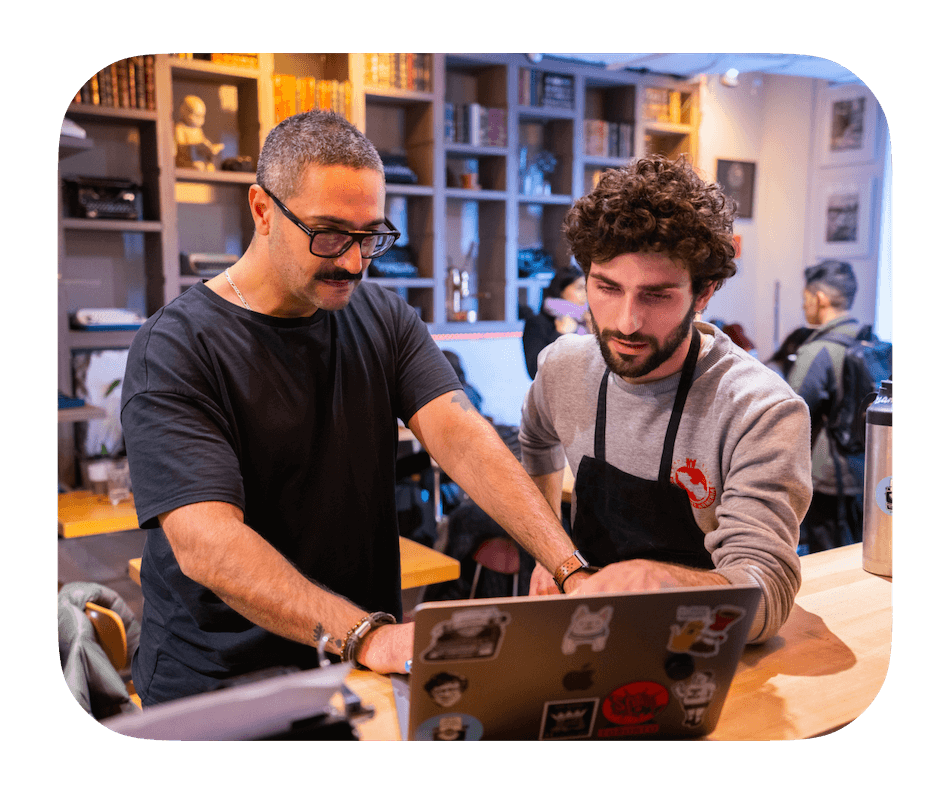 Restaurant employees working together on a laptop.