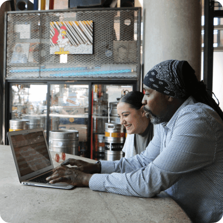 Restaurant employees working on laptop together.